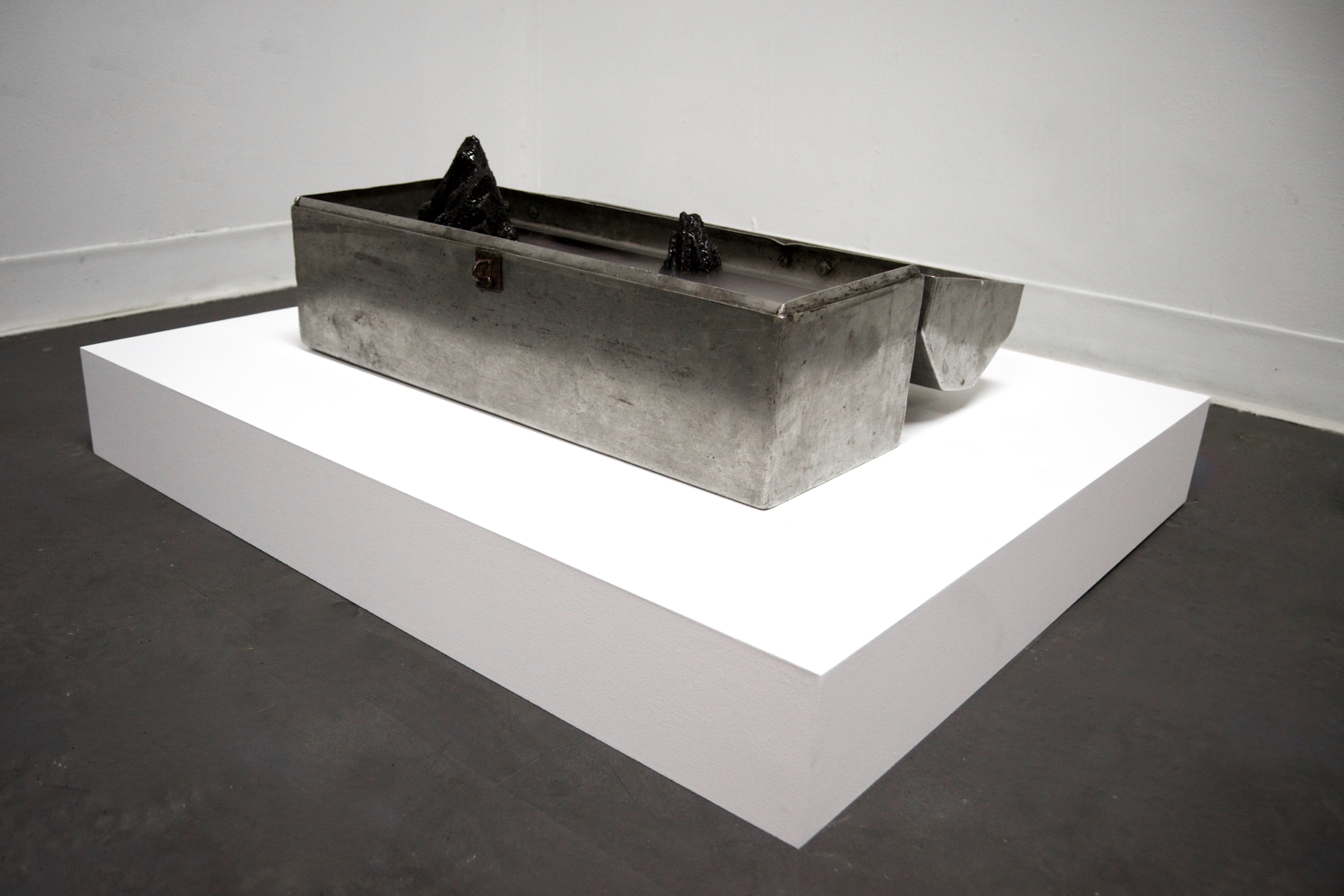 Caroline Hatfield, Depths and Distances, 2019, 5.5" x 20.5" x 15", found object (tool box), resin bonded coal slag, water, mist maker