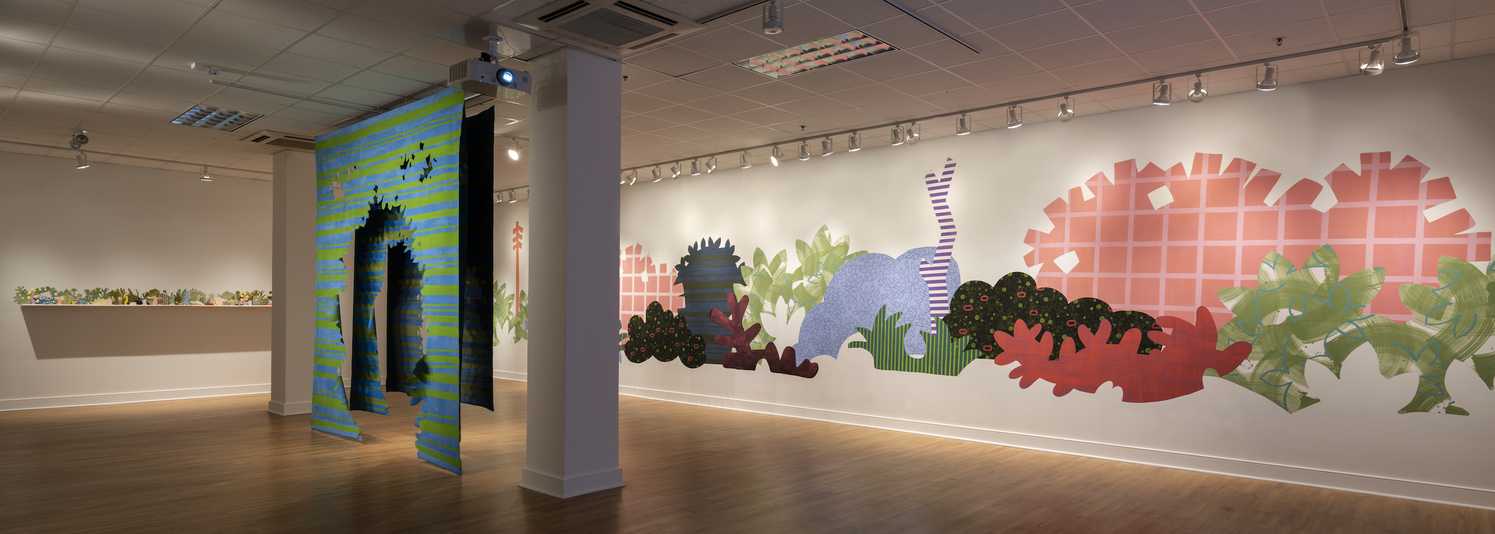 Installation of “Aggregate Optics of Make-A-Do” 2019; University of Memphis, Fogelman Galleries; From right to left: Piecemeal Promenade (2019) 48ft x 11ft; latex on muslin cut-outs, adhered to wall; Proscenium Hedgerow (2018) 11ft x 10ft x 2ft; series of three latex on cut muslin panels; Horizon Allsorts, (2018) 12ft x 1ft; (6) floating wood shelves, painted muslin, ceramic, underglaze and glaze